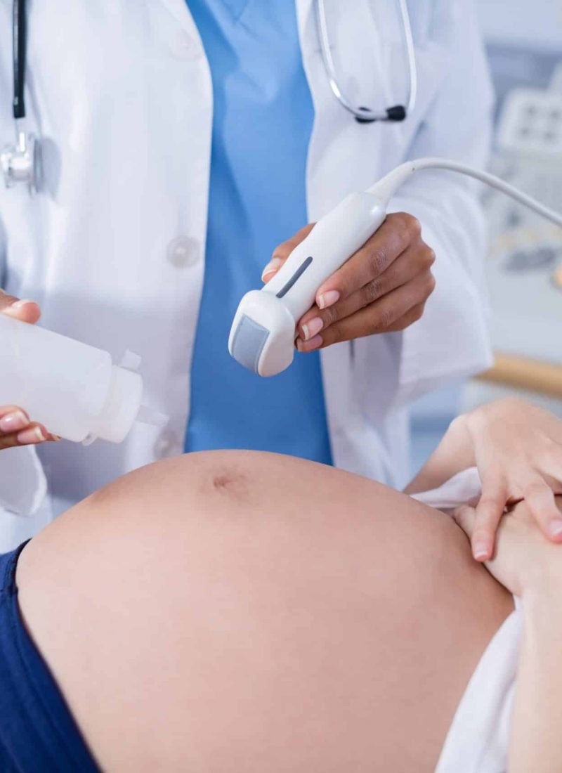 Pregnant woman receiving a ultrasound scan on the stomach in hospital